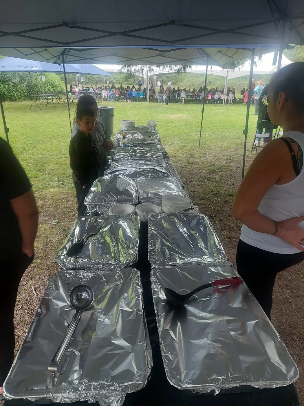 Outdoor buffet line set up under a canopy at a community event