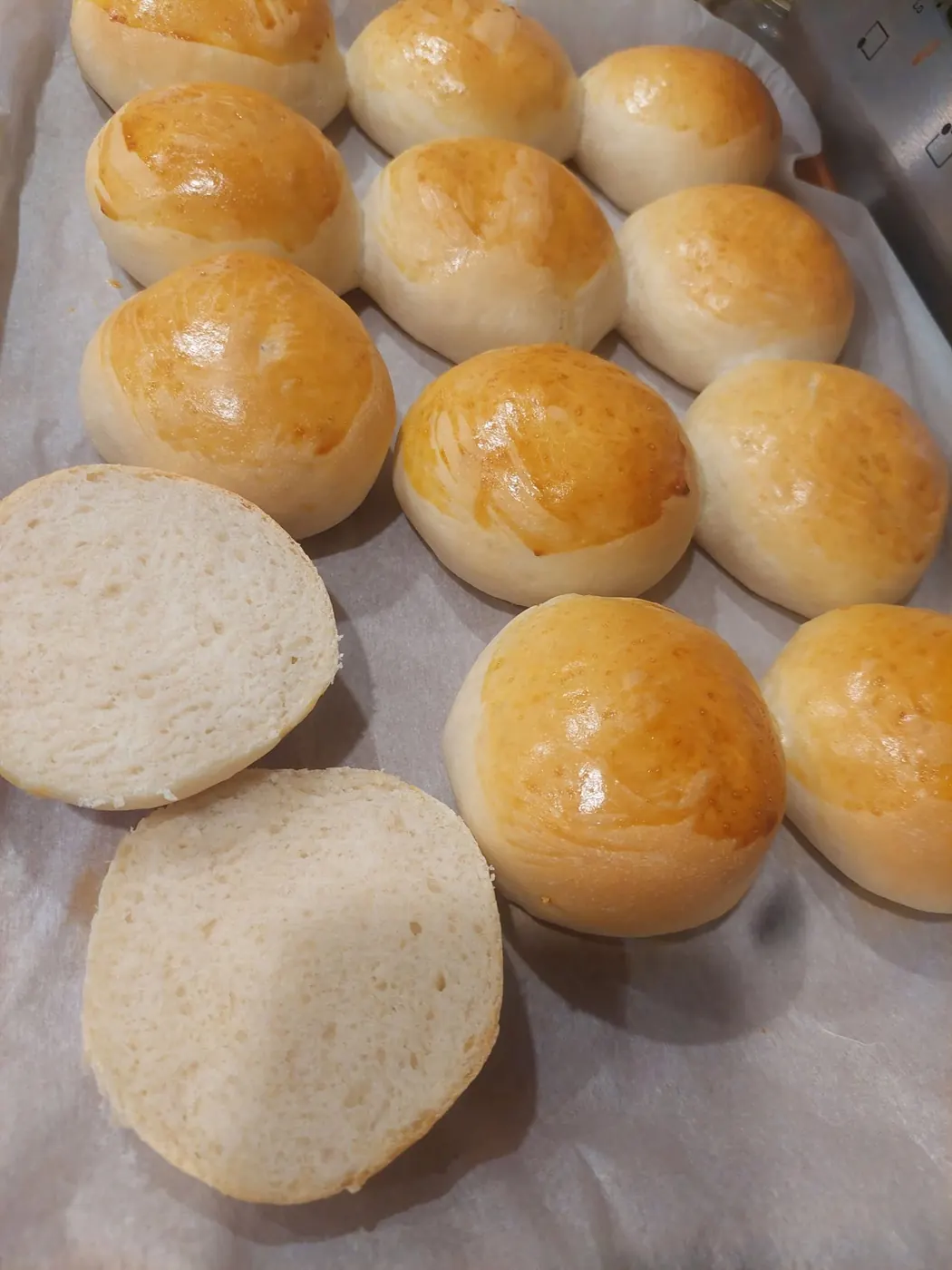 Golden homemade buns fresh from the oven on parchment
