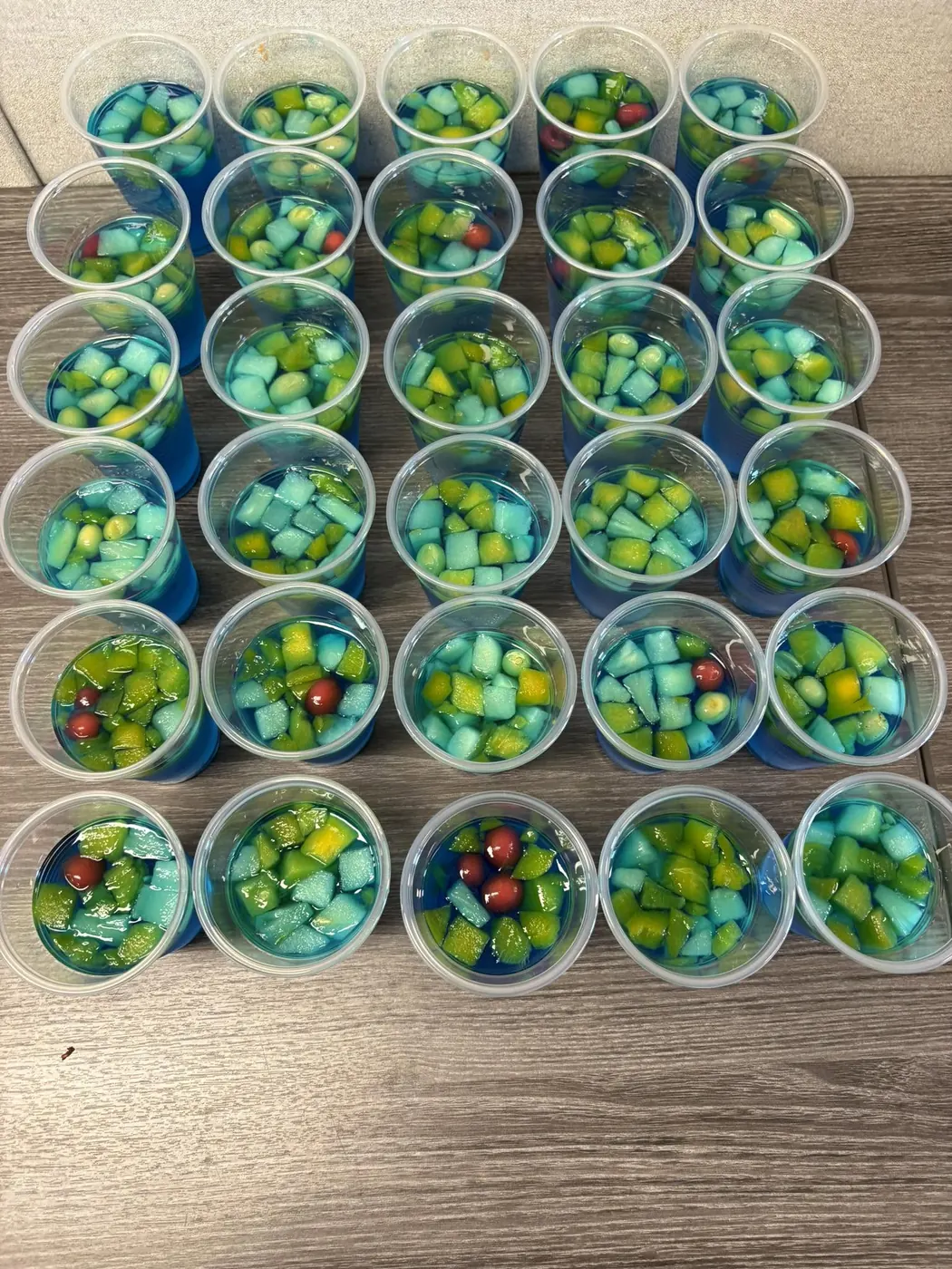 Rows of colourful fruit jello cups ready for guests