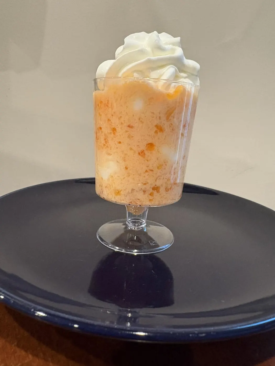 Layered fruit parfait dessert topped with whipped cream